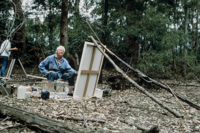 Arthur Boyd painting in on a large canvas in the landscape