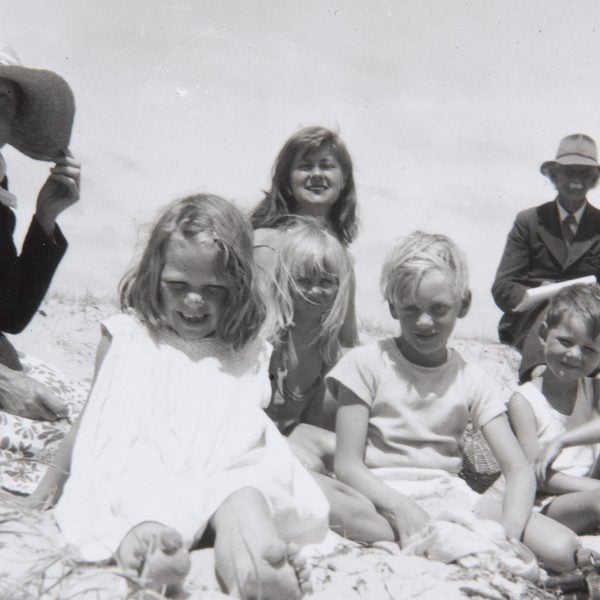 Black and white photo of a family sitting on a beach smiling