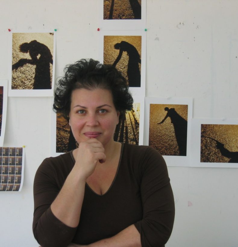 Person standing infront of a wall covered in photographs of shadows.