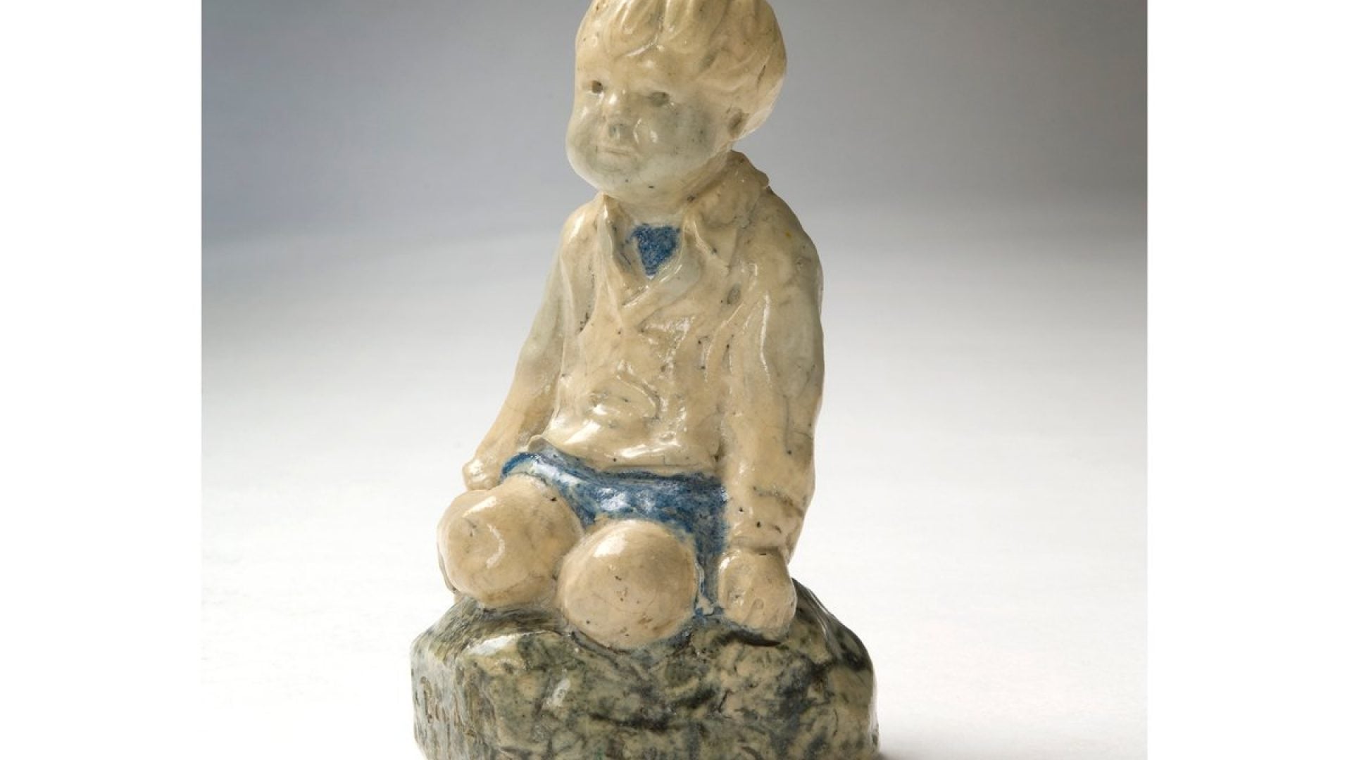 Ceramic sculpture of a small boy kneeling