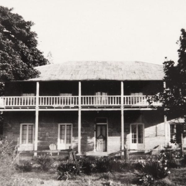 old black and white photo of two story stone homestead