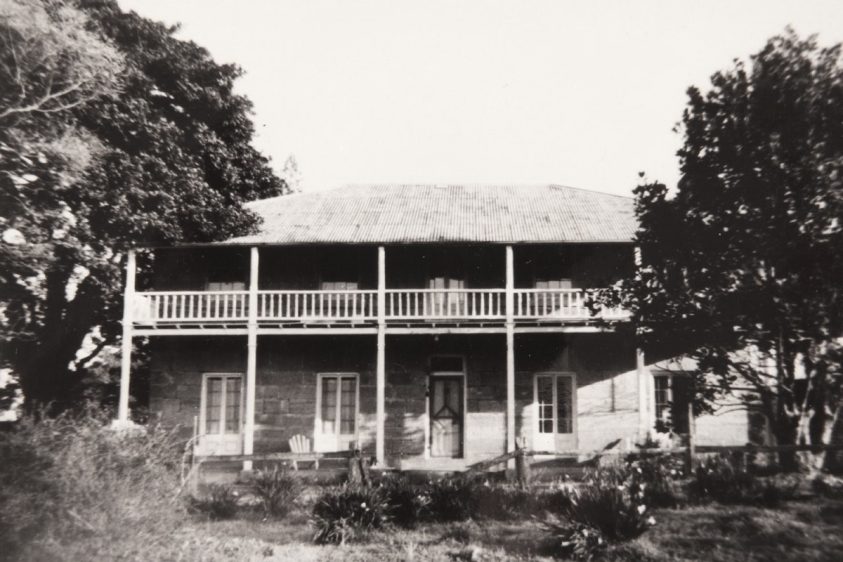 old black and white photo of two story stone homestead