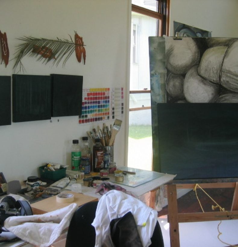 An artist's studio featuring an easel with abstract rock drawing on it