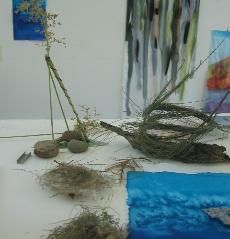 A table with assorted objects made from grasses, leaves and rocks