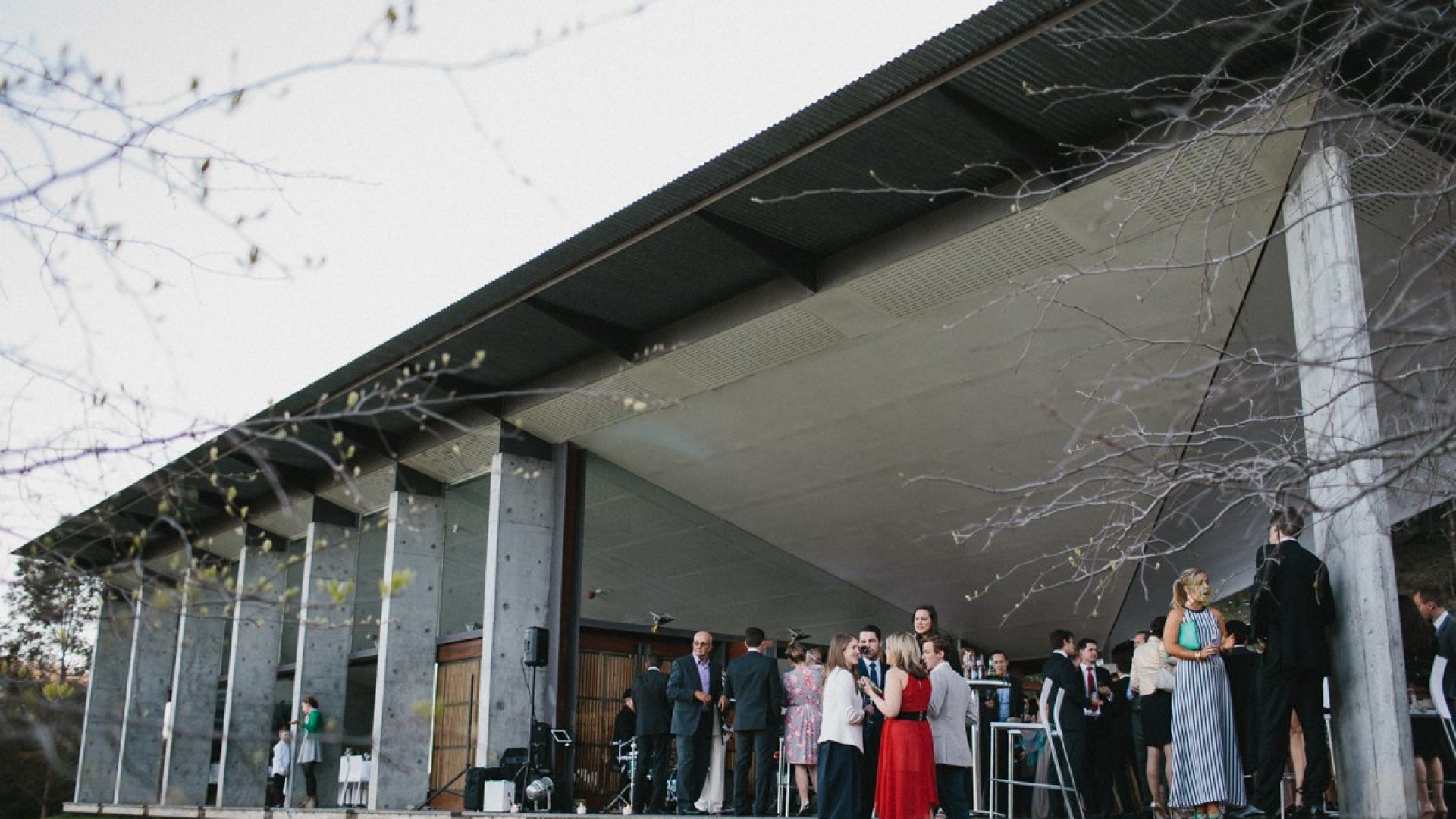 A group of people wearing formal attire are gathered outside a building