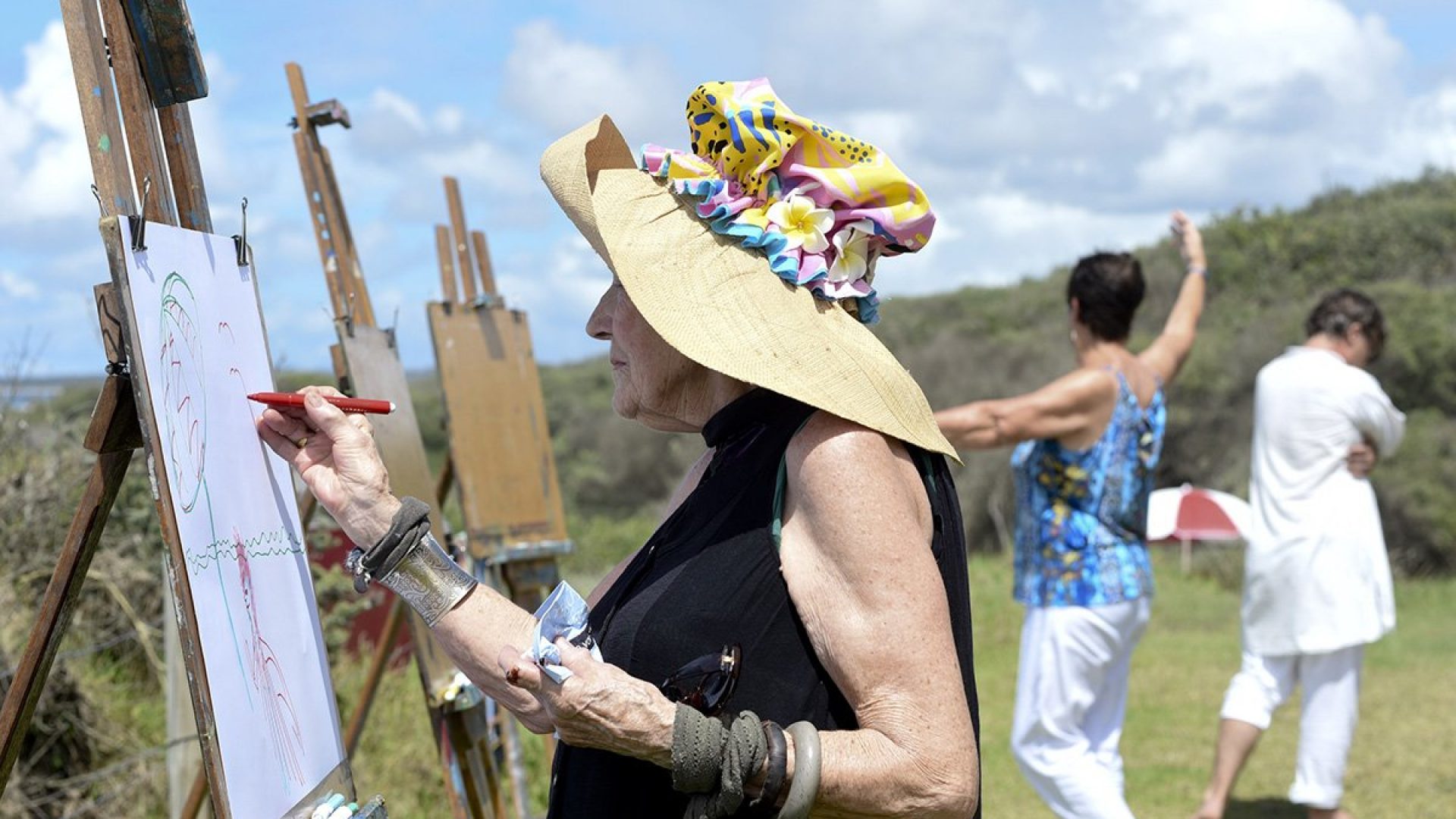 A person standing drawing on an easel
