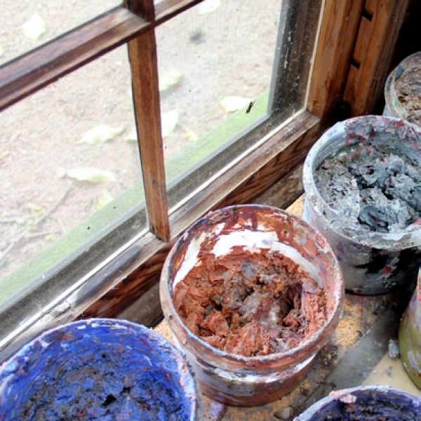 Three large pots of paints on a windowsill