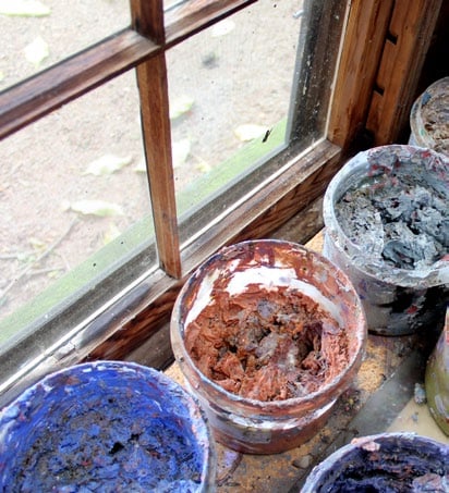 Three large pots of paints on a windowsill