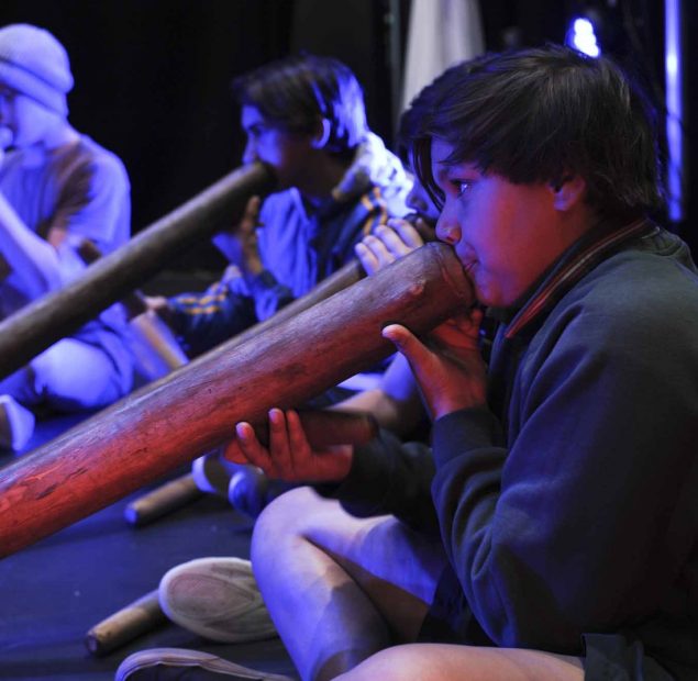 5 young boys playing the didgeridoo