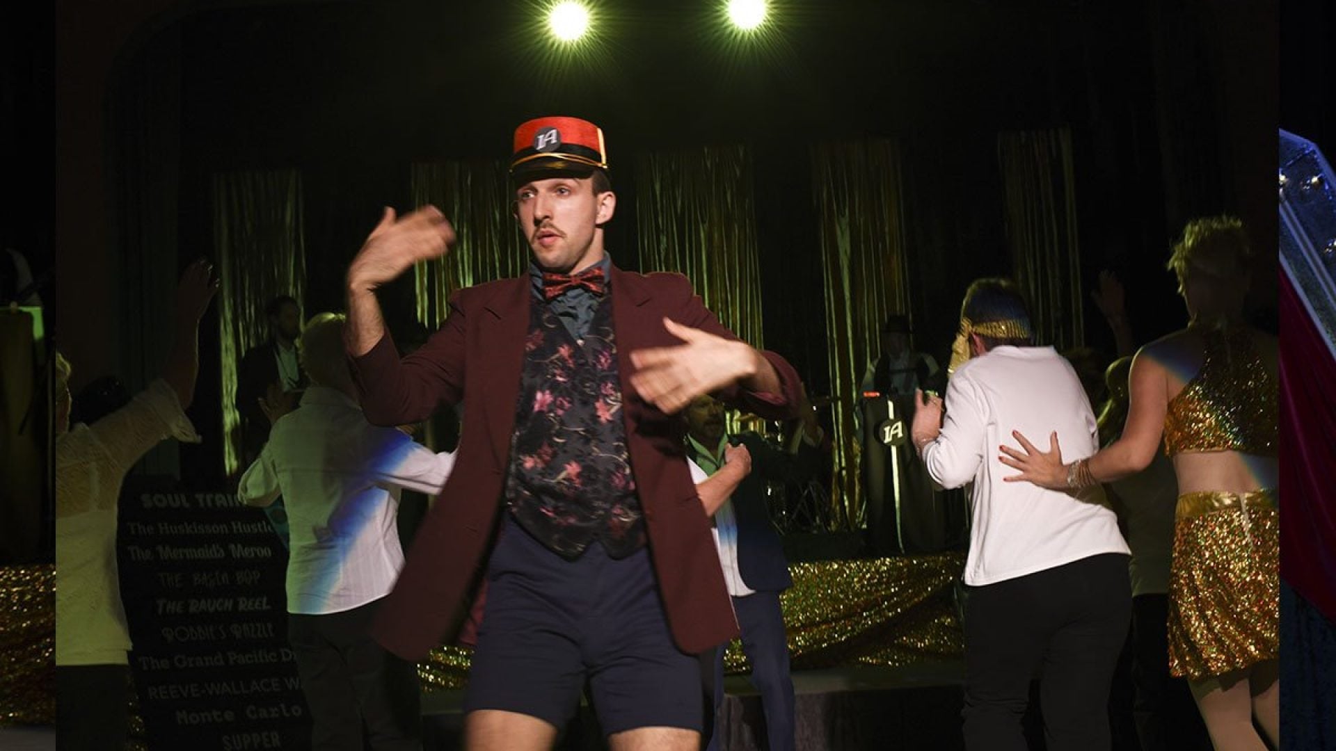 7 people dancing together in a dark room