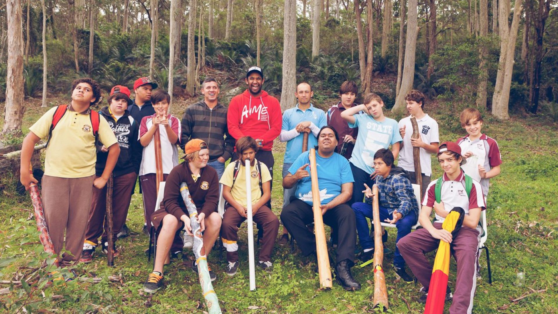 10 young men in the landscape with didgeridoos