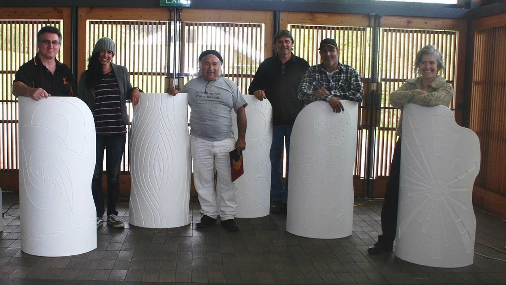 6 people standing together with white sculptural forms