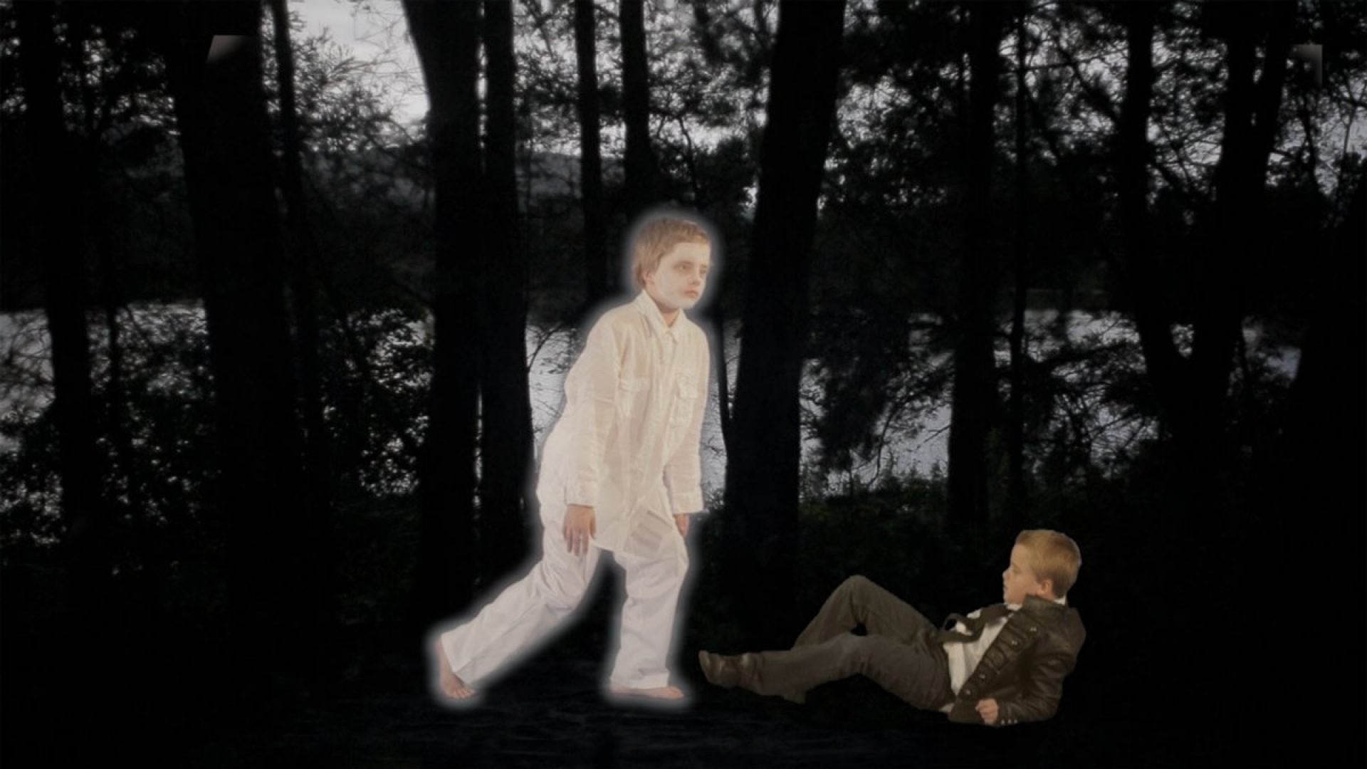 Photograph of 2 illuminated children walking in a dark landscape