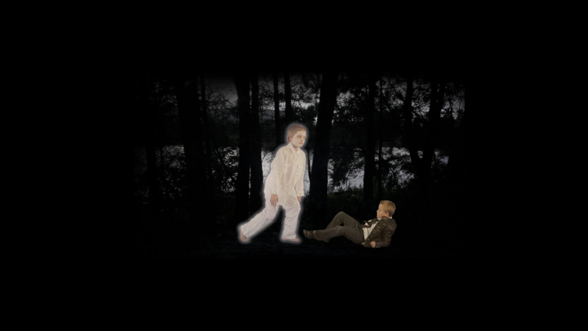 Photograph of 2 illuminated children walking in a dark landscape