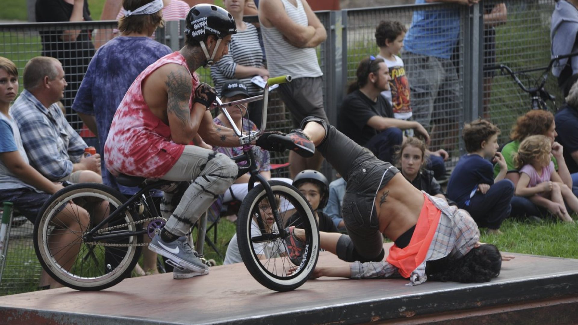 Bike rider in a skate park, with lots of people watching