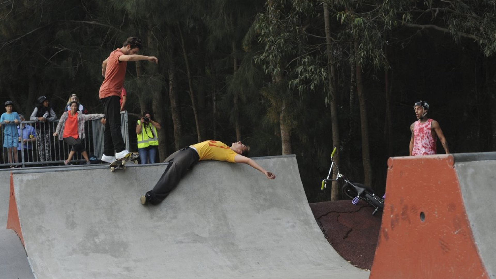 Skate boarders skating on a concrete half pipe
