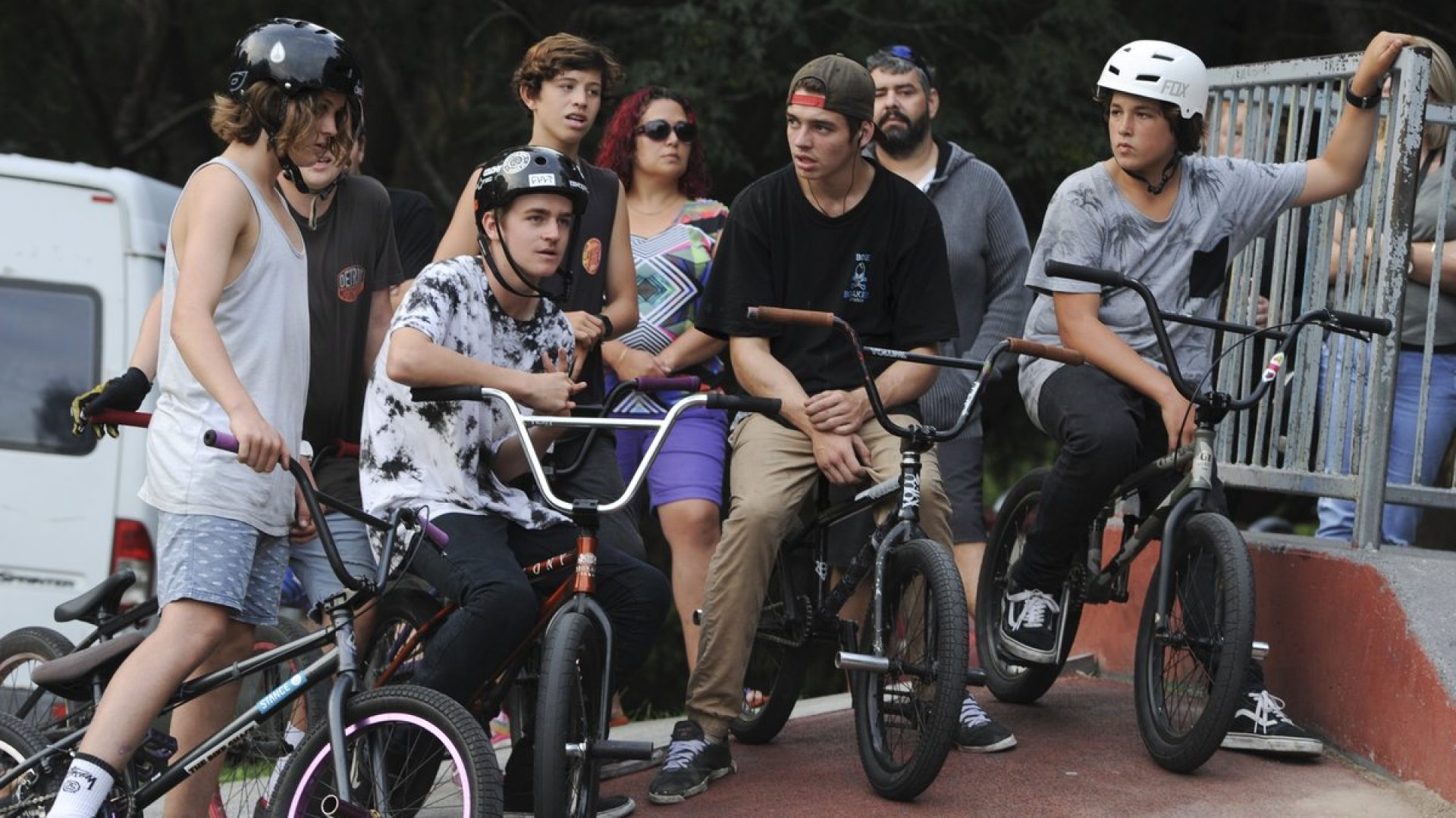 4 people sitting on small bikes at a skate park