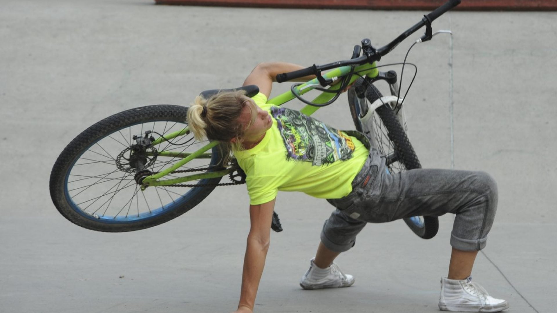 Person leaning back and holding a bicycle