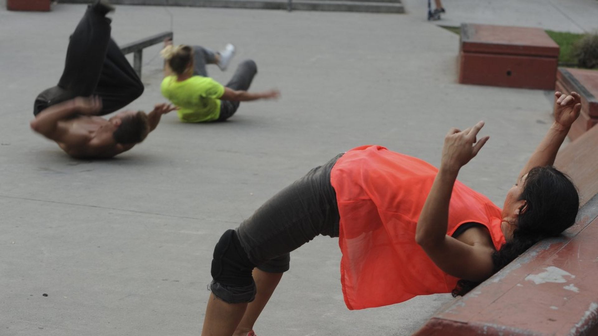 3 people dancing in a skate park