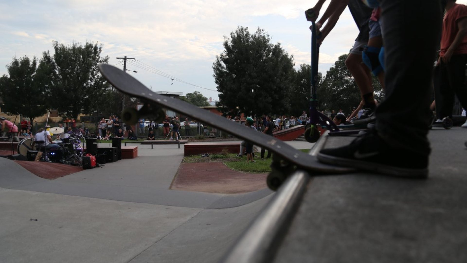 A skatepark with a skateboarder getting ready to go down a half pipe