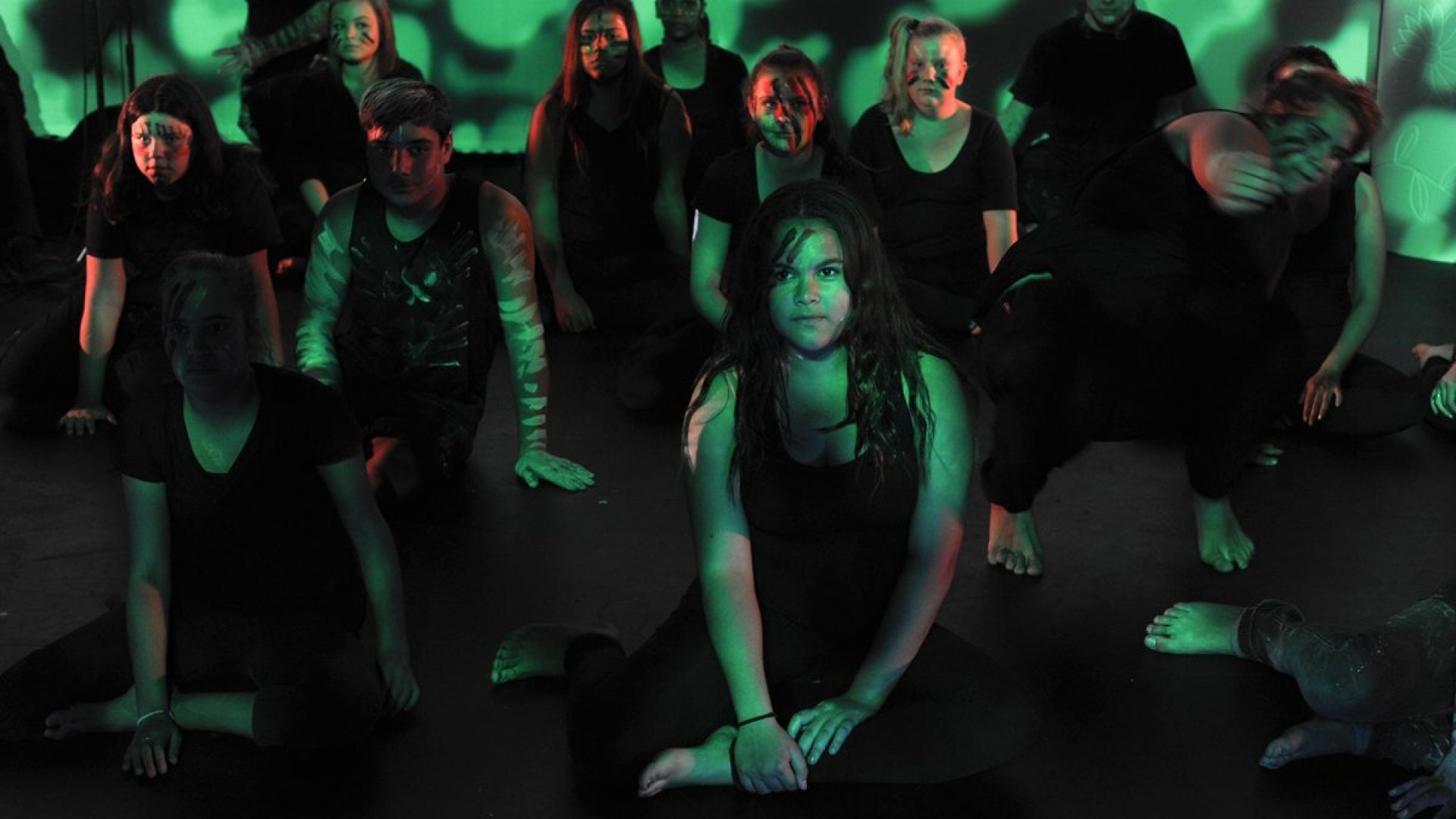 12 young people dancing on stage