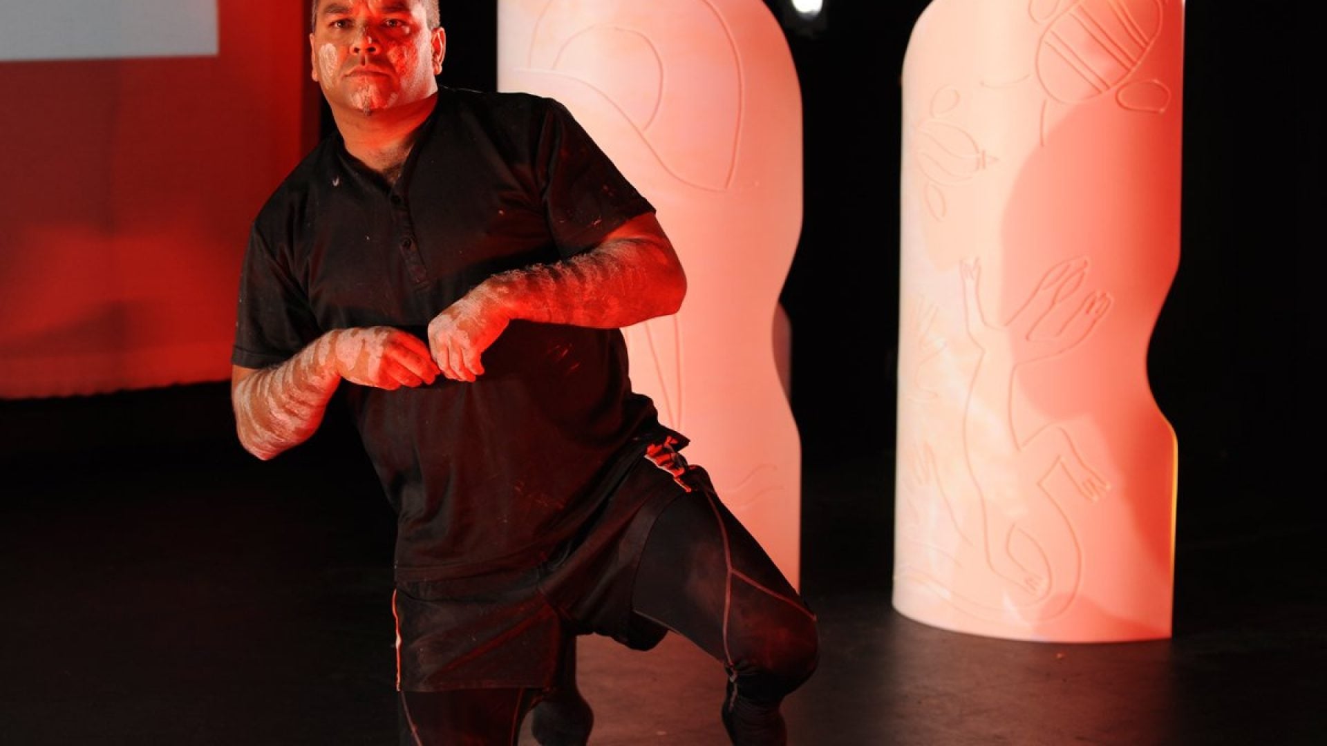 Person on stage kneeling on the ground