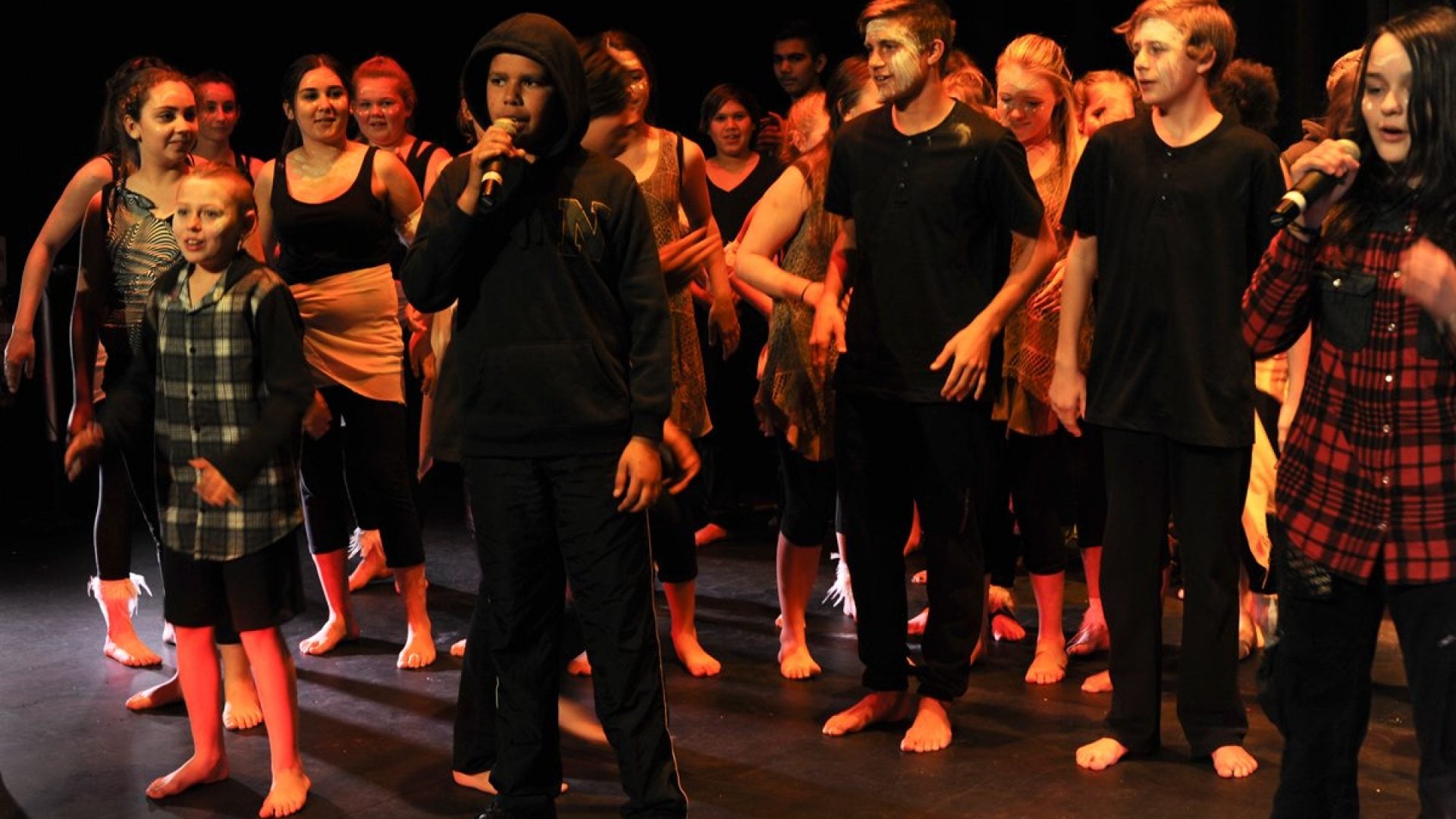 20 young people singing on stage