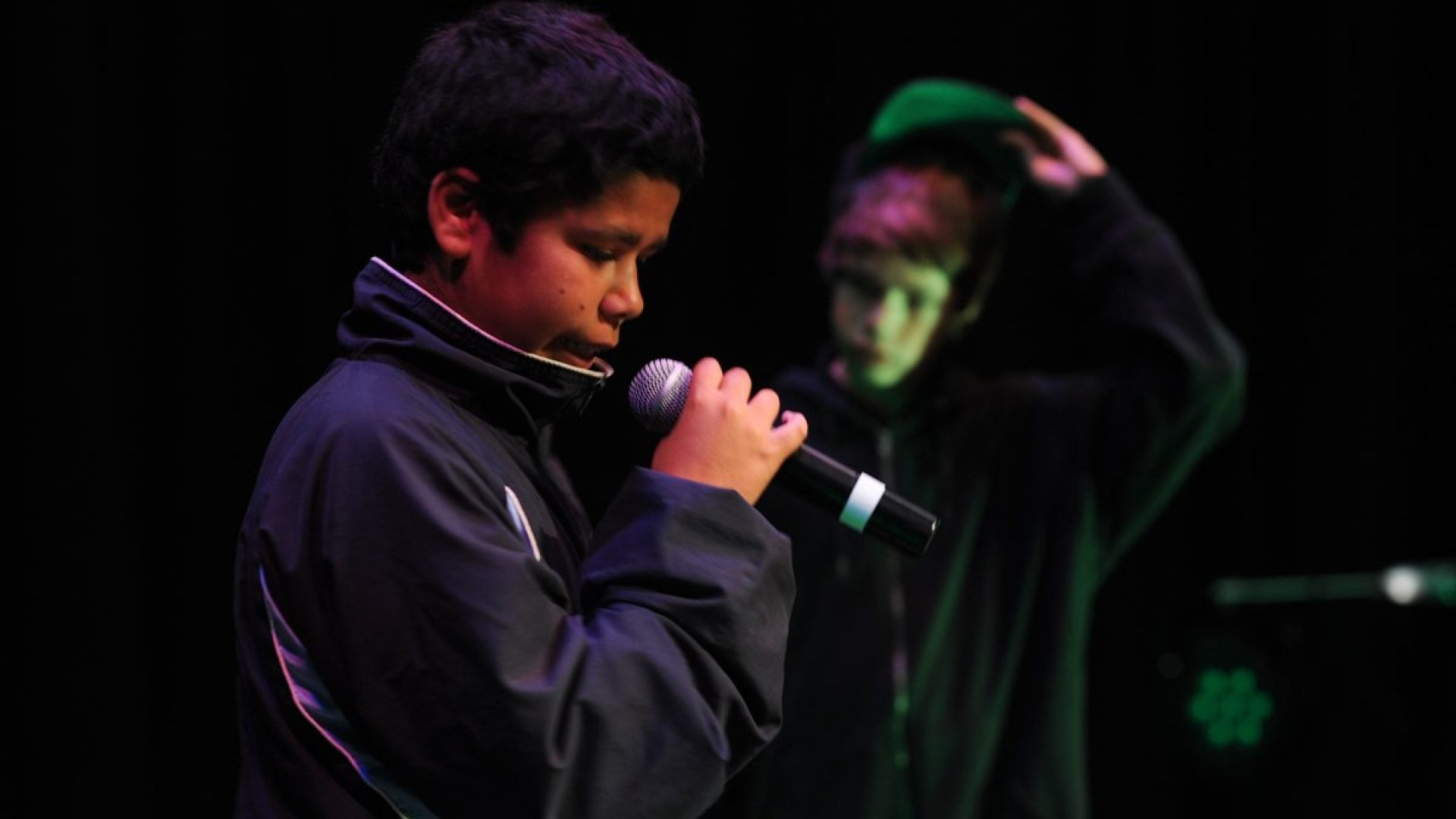 Young kid talking into a microphone