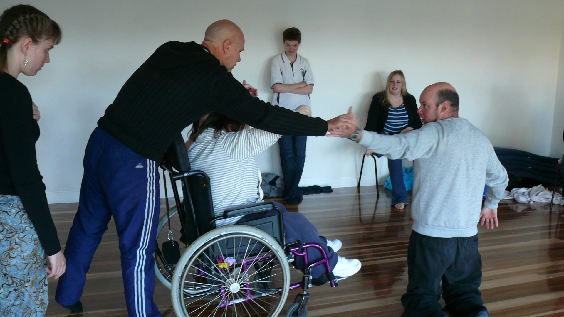 A person in a wheelchair with people standing around them