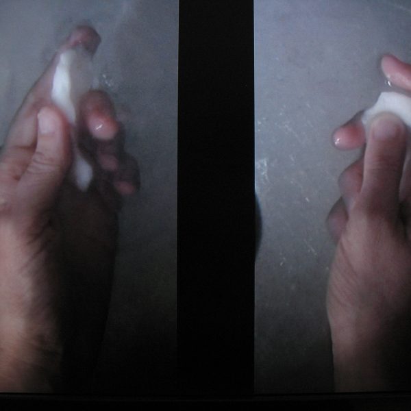 Two hands holding white objects