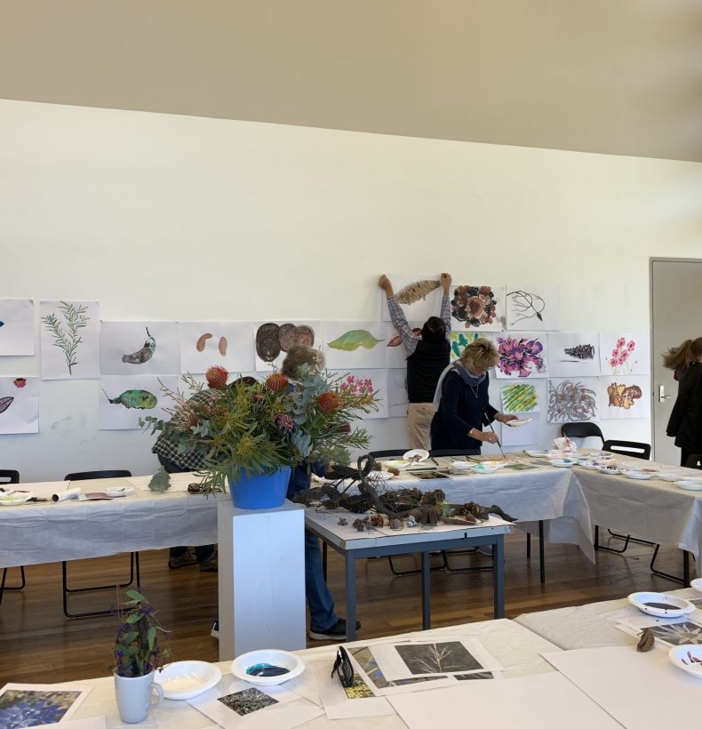 Tables in a room with bowls of art materials and organic matter