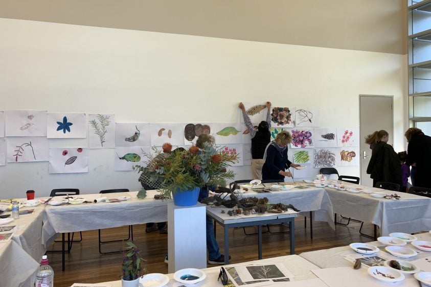 Tables in a room with bowls of art materials and organic matter