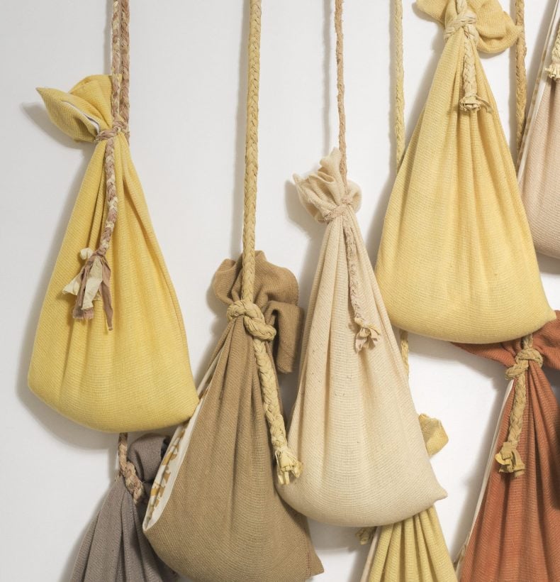 8 brown sacks hanging by rope on a wall