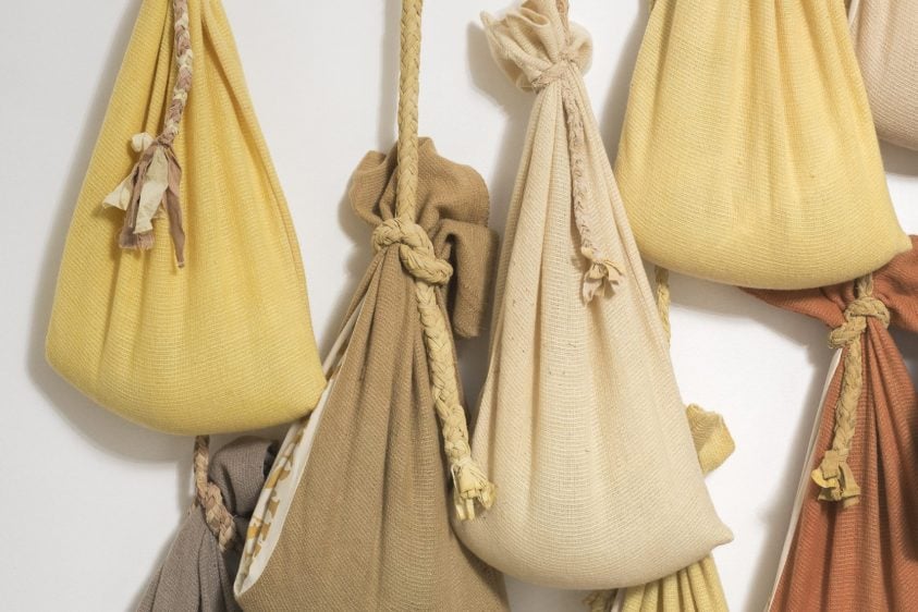 8 brown sacks hanging by rope on a wall