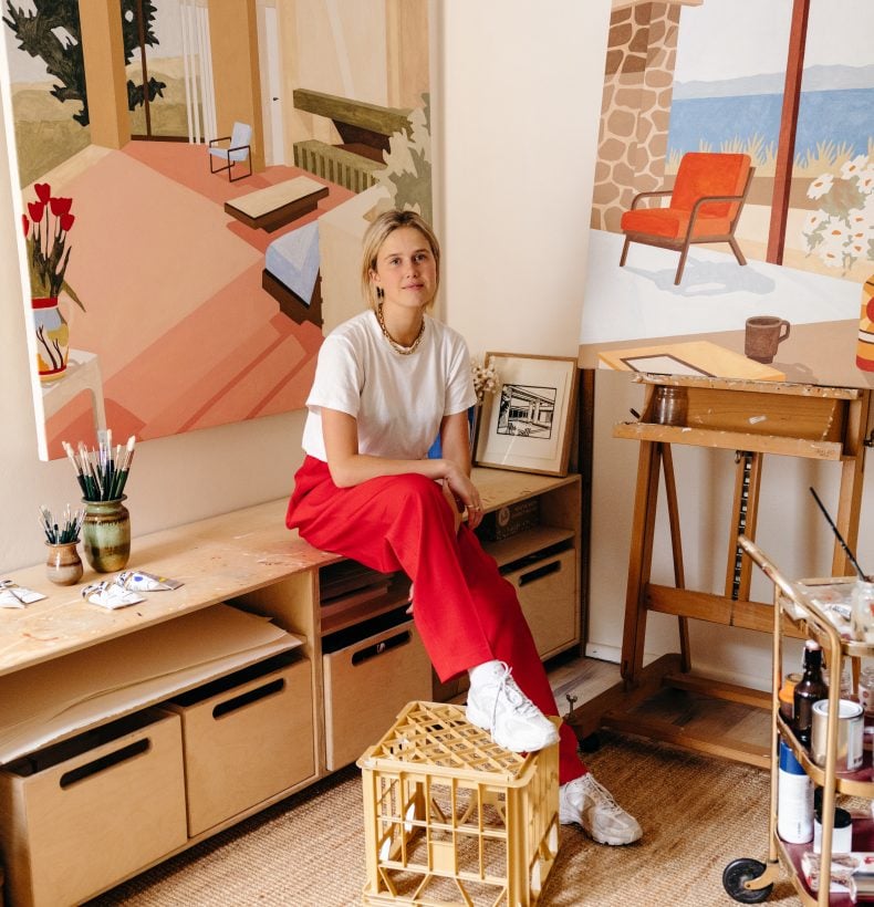 Photo of Eliza Gosse in her studio surrounded by her artworks