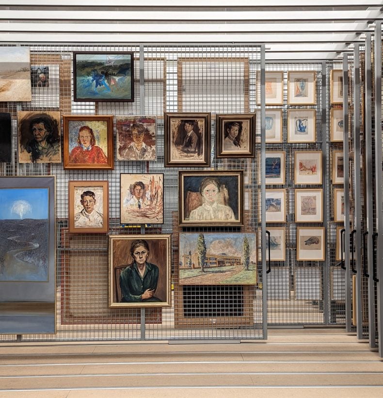 Cage of paintings hanging in storage on display.