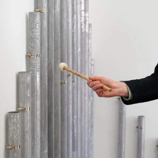 Madison Kelly, toko by and by (2022). Marine grade aluminium, hose clamps, mallets and sticks. Photo credit: Blue Oyster Art Project Space