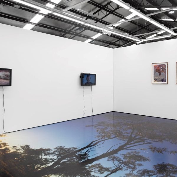 Jahkarli Felicitas Romanis, Installation photograph from the exhibition ‘(Dis)connected to Country,’ Hillvale Gallery, Victoria, 2024. Video works shown (left to right) ‘wapa (look for), wantili (wait for), irrhka (feel)’, 2023 and ‘Dear Dolly, With Love II’, 2023. Photographs shown ‘Pitta Pitta’, 2019 (floor), ‘Dolly’ 2021 (left), ‘Dolly’ 2024 (right). Photo: Hannah Nikkelson
