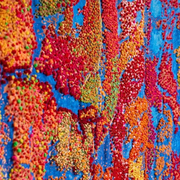 A detail view of Jo Mellor’s intricate and embroidered threads as they form patterns and mappings of place on fabric.