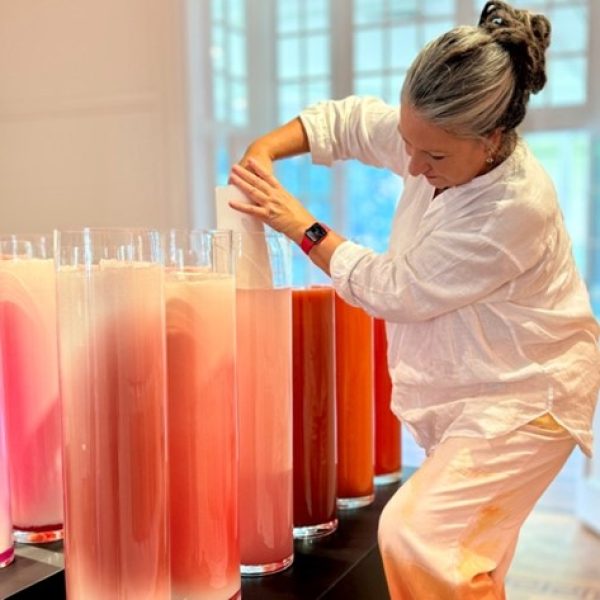 Natalie O’Connor submerges paper into the red pigments as part of the installation, Gol Gol Layer Colour Observation 9 in the Nature of Redness at Woollahra Gallery at Redleaf. 2024
