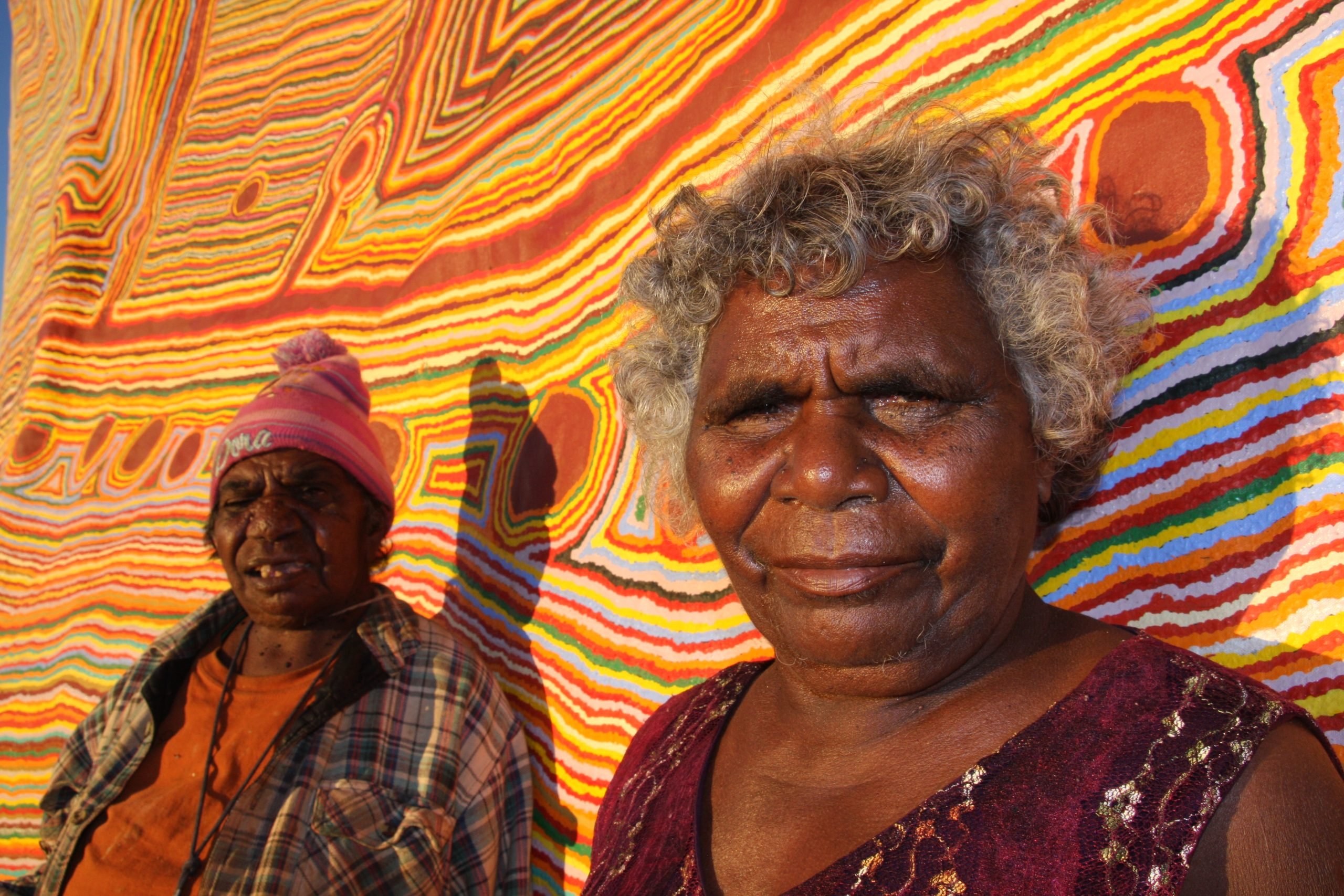 Kumpaya Girgiba and Ngamaru Bidu close up in front of painting. Photo by Gabrielle Sullivan.