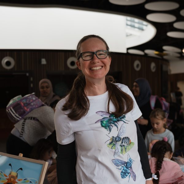 Person smiling in an event with people.