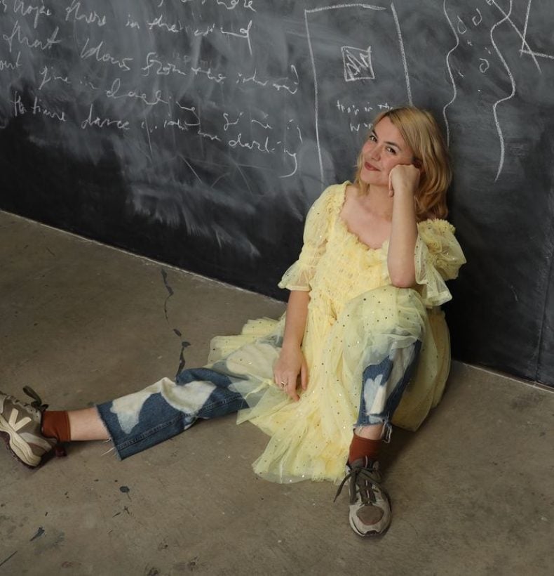 Woman sitting on the floor on a wall.
