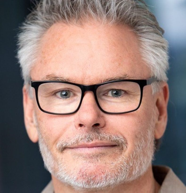 Three people sitting in the back of a van looking at the camera.