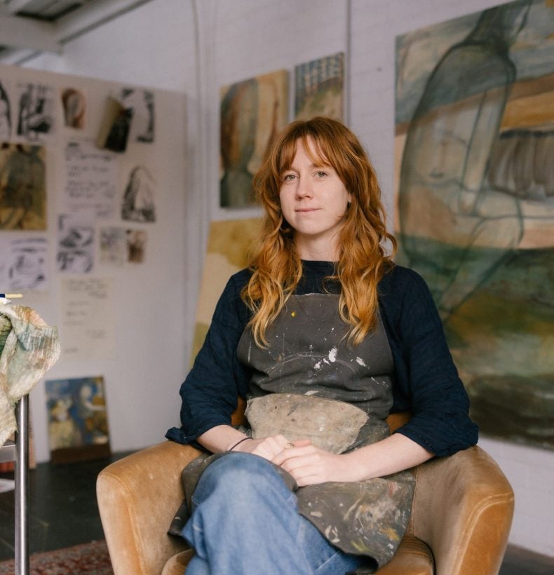 Woman sits peacefully in her studio chair.