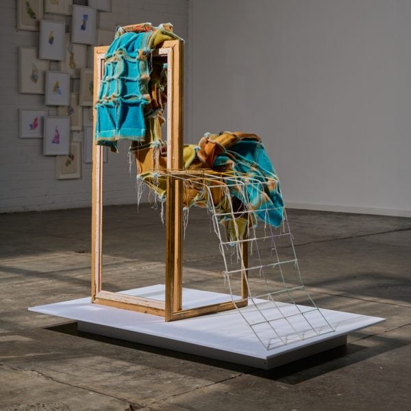 ReFrame, 2025, blanket, needlepoint/tapestry, wool, thread, timber, wire. H124 x W110  x D80 cm. Photo: Kit Edwards