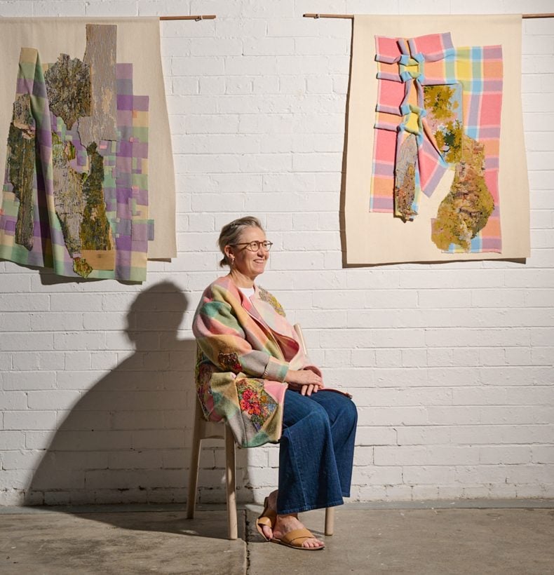 Woman sits on a chair with two artworks on the wall.