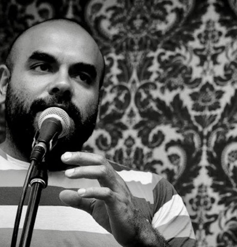 Portrait of Bryan Andy speaking into a microphone.