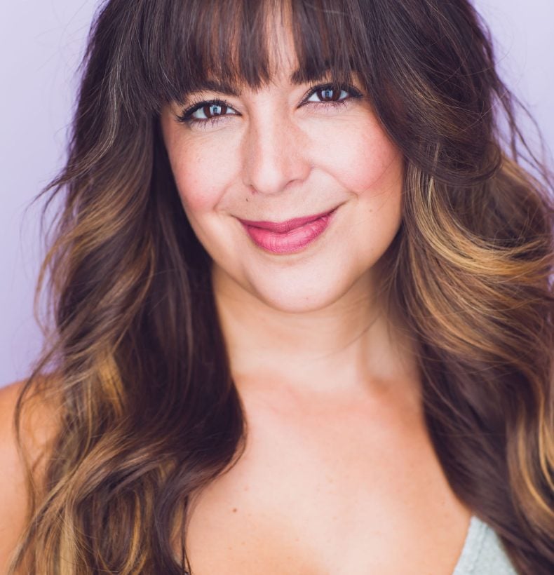 Studio portrait of woman with long brown hair.