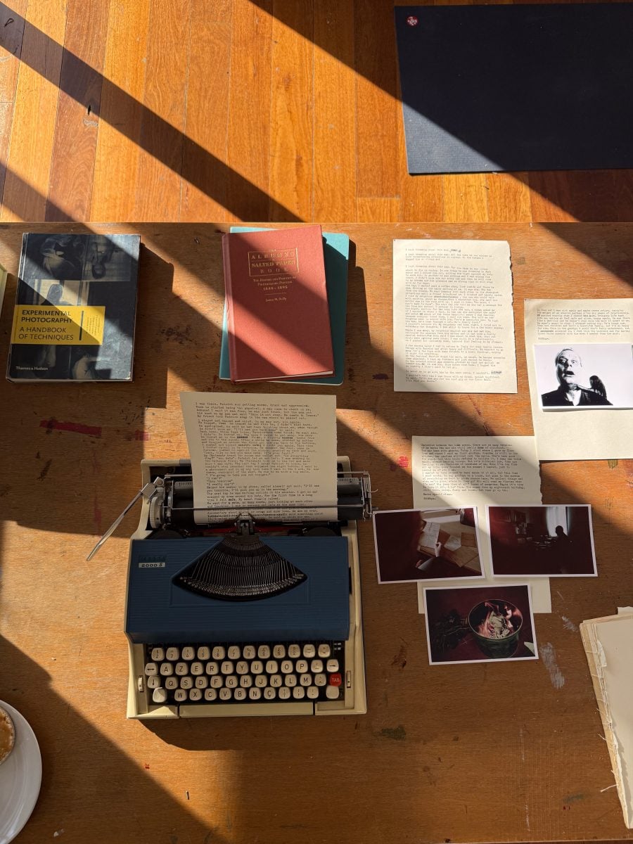 Typewriter on a desk with a flatlay of papers